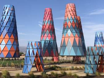 Various cone-shaped towers in shades of blue, orange, red and pink located at a park in Indio.