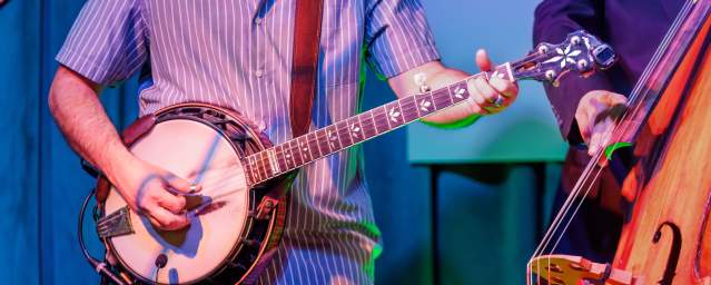A musician plays the banjo at a music venue.