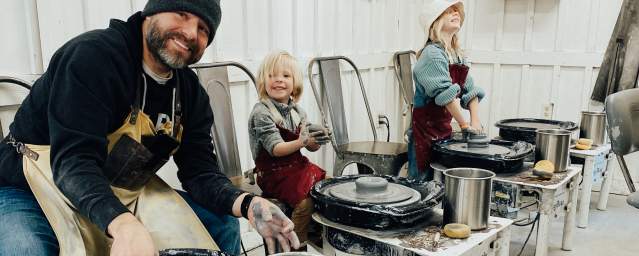 father with kids at pottery class