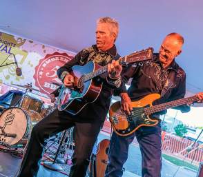 Two men playing guitars on stage at Chelsea Sounds & Sights Festival