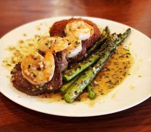 Steak, shrimp and asparagus dinner with butter sauce