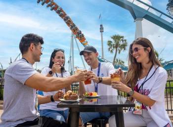 Two couples enjoy food and beverages at SeaWorld Orlando's Red, White & BBQ event.