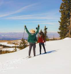 Two Snowshoers with their arms in the air on the Grand Mesa