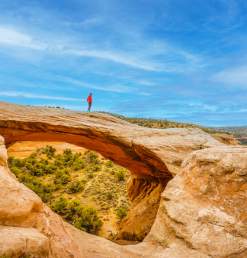 Man walking across Rattlesnake Arches