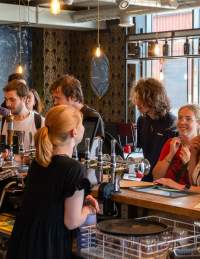 People at bar in Junction, Wapping Wharf - credit Hey What