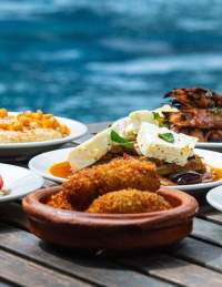 Selection of small plates on a table by a swimming pool/ lido