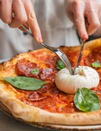 A person eating one of the pizzas at Pizza on the Park in central Bristol - credit Pizza on the Park