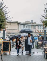Group walking through Wapping Wharf, Bristol in the rain - credit Food Tours of Bristol