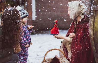 A women dressed in a red robe showing a doll to a small child - Credit Brunel's SS Great Britain