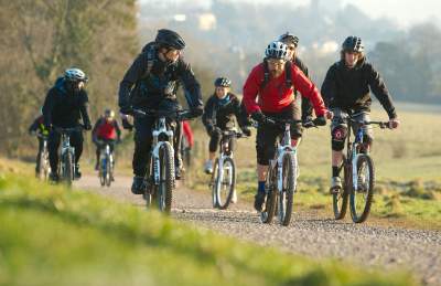 A group cycling on rented mountain bikes towards the off-road mountain biking trail at Ashton Court - credit Pedal Progression