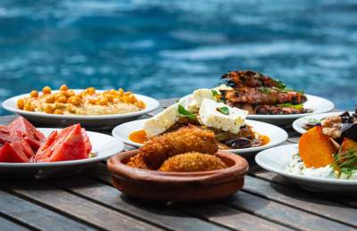 Selection of small plates on a table by a swimming pool/ lido