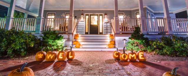 The Inn at Hastings decorated with pumpkins lit up along the front walkway.
