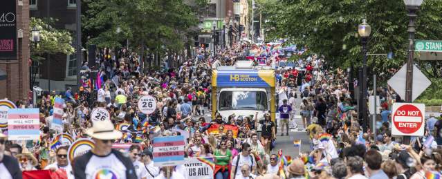 people walking down the street in celebration of the Pride Parde. featuring the mobile VIC.