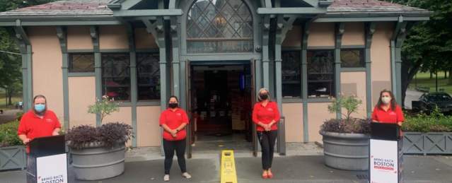 4 people wearing masks and standing several feet from each other in front of the Visitor Center