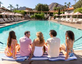 Friends hanging out poolside at the Tommy Bahama Miramonte Resort