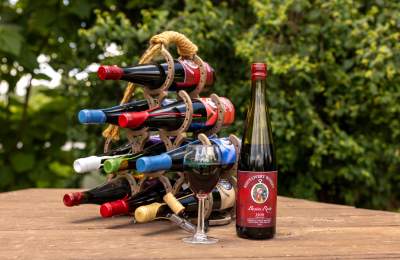 Photo of multiple bottles of wine, a glass of wine and someone opening a bottle of wine. All from Reid's Livery Winery in Bowling Green, KY.