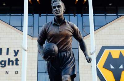 A statue of a footballer in front of Molineux football stadium