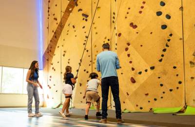 Family of 4 doing the rock climbing wall at Rush Extreme.
