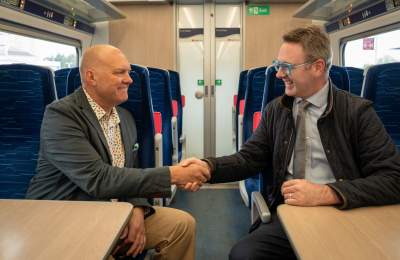 VHEY advisory board chair, Chris Blacksell, shaking hands with Richard Salkeld from Hull trains, while sat on a train