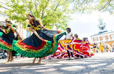 Colorful dancers performing traditional cultural dances during the Parade of Nations during the International Folk Festival in downtown Fayetteville, NC.
