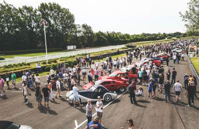 crowds stand around sports cars at Goodwood motor circuit