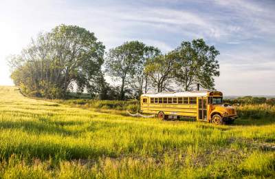 A converted american school bus in a field