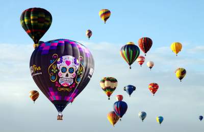 Muerto Balloon joins other hot air balloons in the clear New Mexico sky.