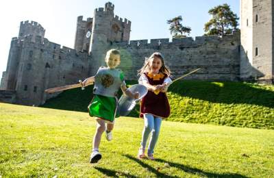Two children at Warwick Castle holding swords