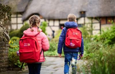 A girl and a boy wearing red backpacks at Anne Hathaway's Cottage