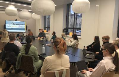 People seated at a conference table, watching a presentation.