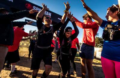 Spartan racers cheering as they cross the the finish line