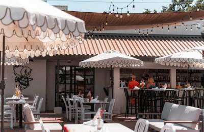 Restaurant patio with tables, chairs, umbrellas, outdoor bar and lights