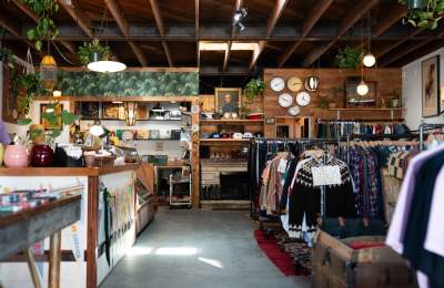 Interior of a rustic thrift shop with plants and clothing racks