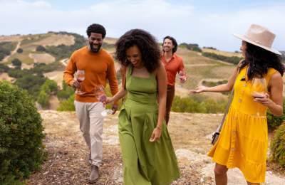 Friends walking through a vineyard in Paso Robles, San Luis Obispo County, California