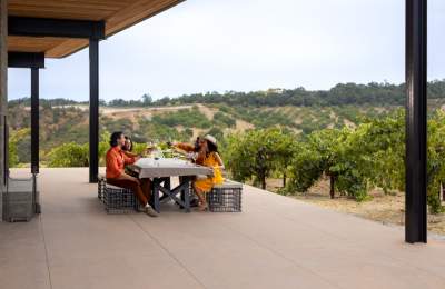 Group of people at table in vineyard wine tasting