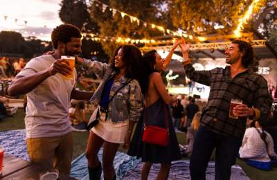 Group of friends dancing under twinkling lights at a live music venue