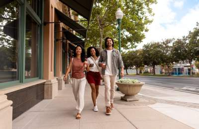 Three people walking together along downtown sidewalk in Atascadero, CA