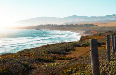 Coastal landscape with mountains, waves and orange and green cliffs