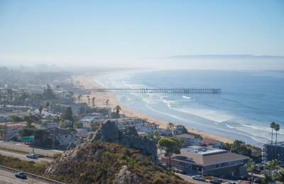 View of cloud cover, coast-line and pier from above