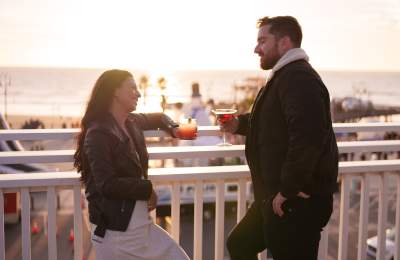 Couple enjoying a drink at a rooftop bar overlooking the ocean