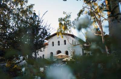 View of mission through the plaza with trees and umbrellas