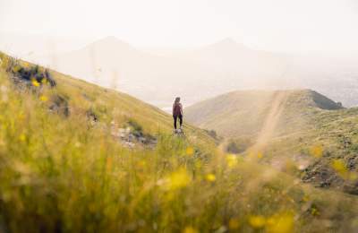 Women standing on side of mountain with backpack