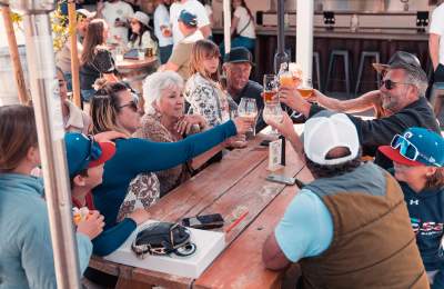 Group of people of varying ages sitting and raising glasses together
