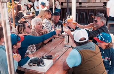 Group of people of varying ages sitting and raising glasses together