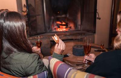 girls enjoying wine and s'mores by the fireplace at Hotel Cheval