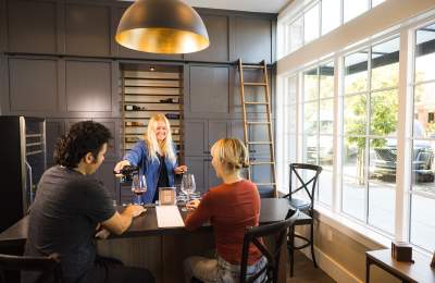 Couple enjoying wine tasting led by tasting room associate