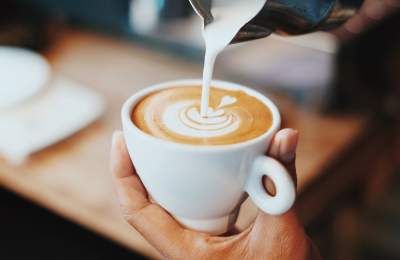 Pouring latte art into white cup