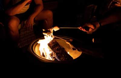People roasting s'mores over the fire pit