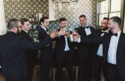 7 men in suits toasting with drinks