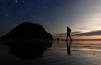 man walking beach at night
